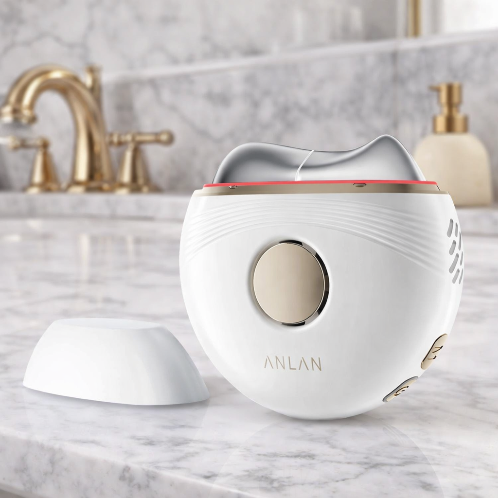 Appareil gua sha électrique EMS ANLAN posé sur un plan de salle de bain en marbre pour massage et lifting du visage