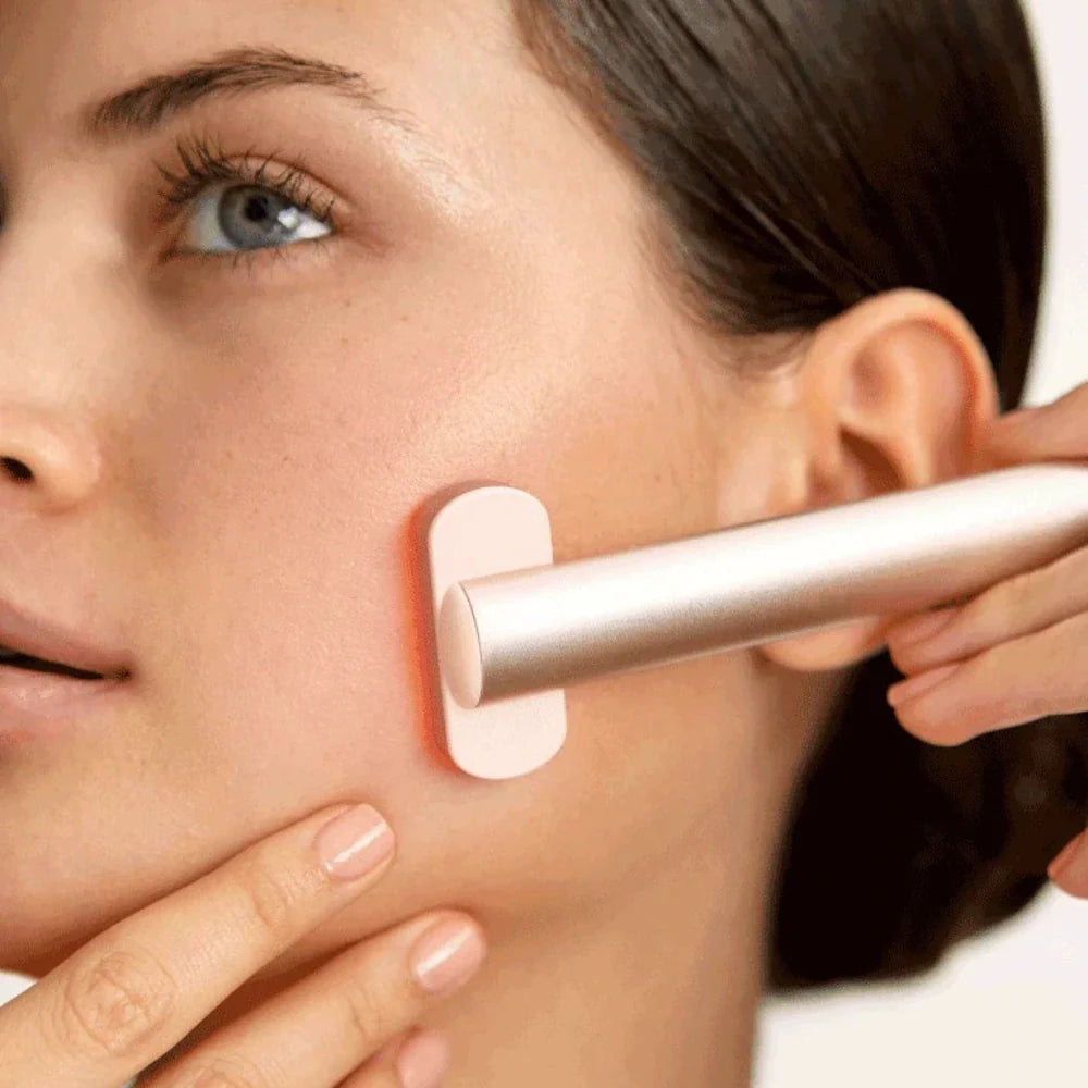 Massage du visage avec un appareil EMS à lumière rouge pour stimuler la peau et réduire les rides